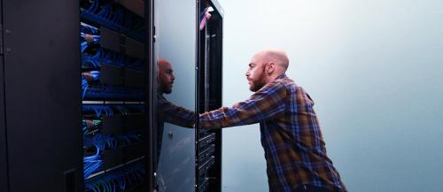 Male computer technician reviews a ϲͼȫ computer server.